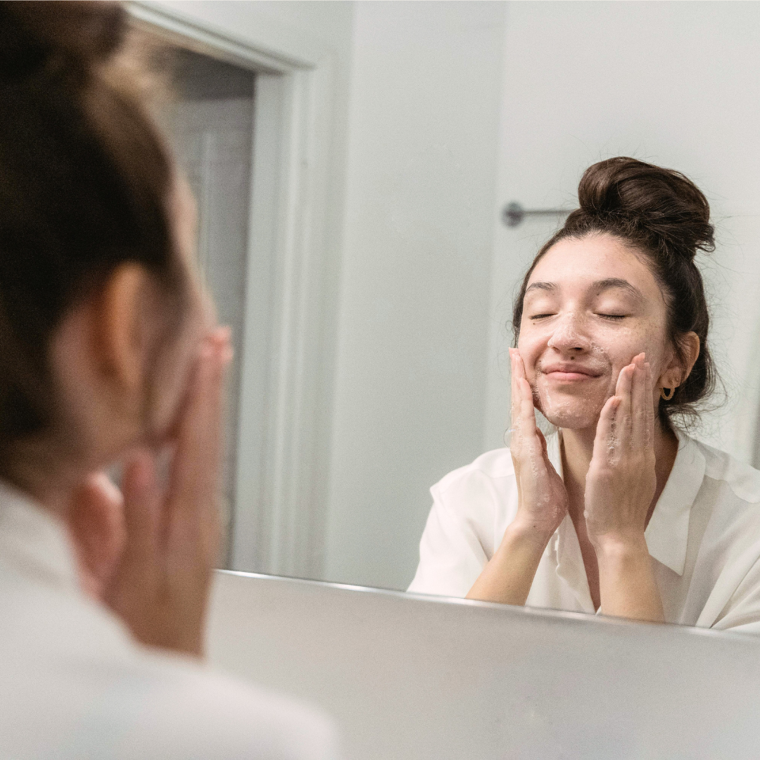 woman with hormonal acne washing her face